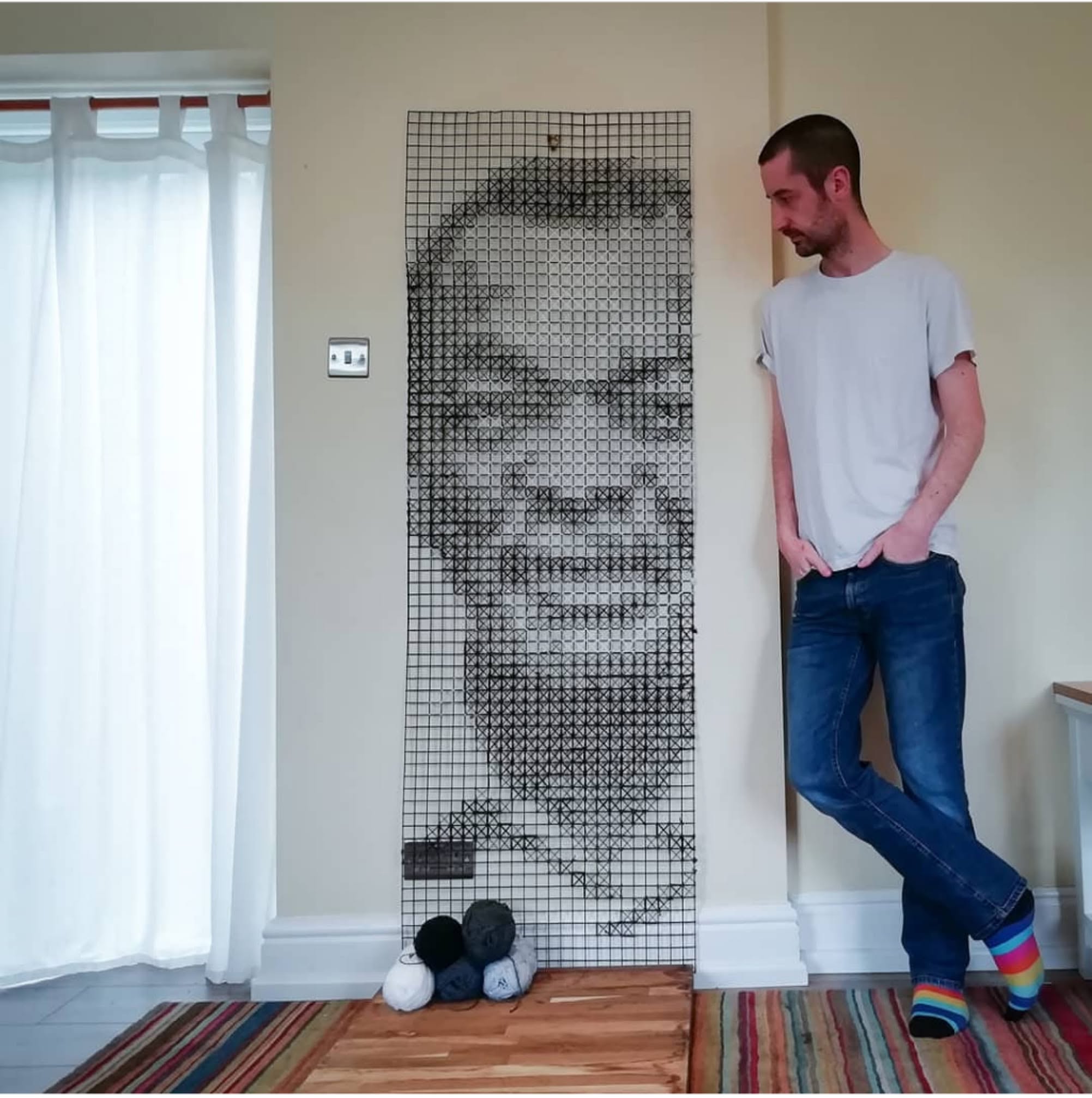 A large format cross stitch of Dr. Edmund Adedeji.