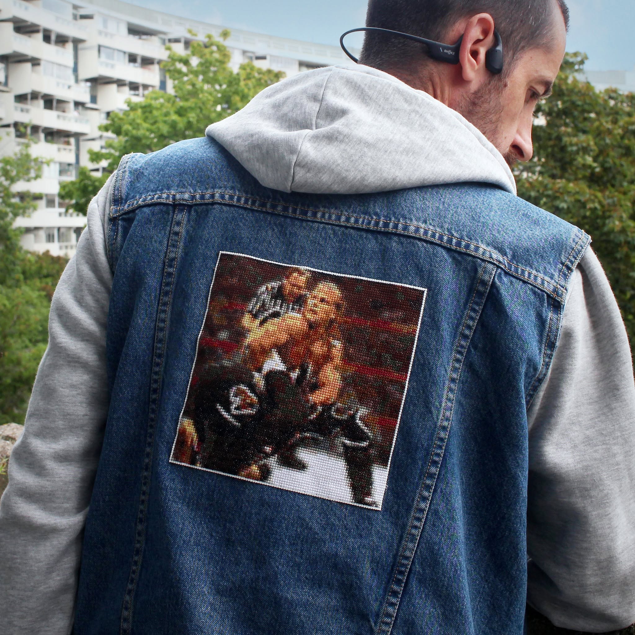 A cross-stitch of the Montreal Screwjob, attached to a denim jacket.