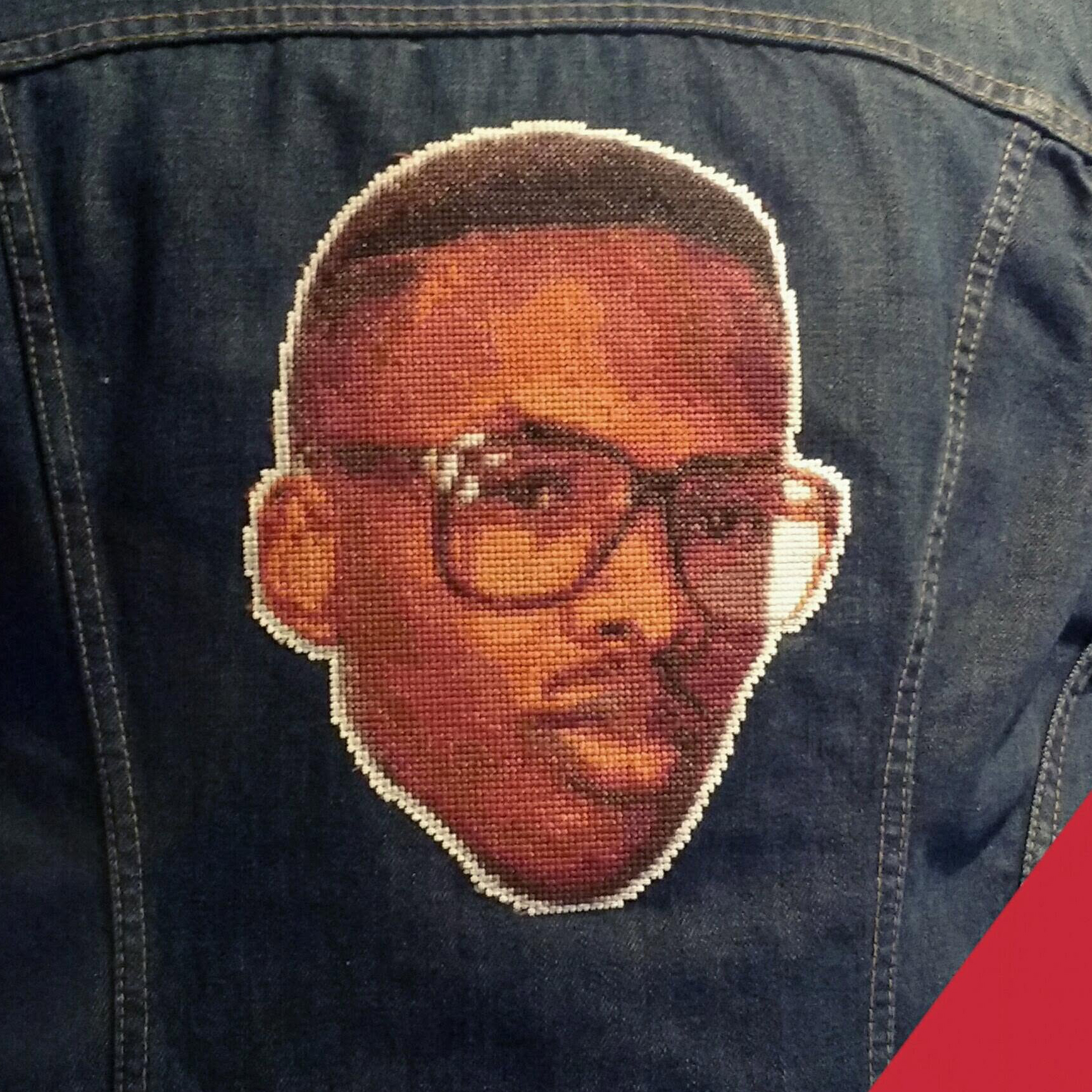 A cross-stitch of Jazzy Jeff, on a denim jacket.