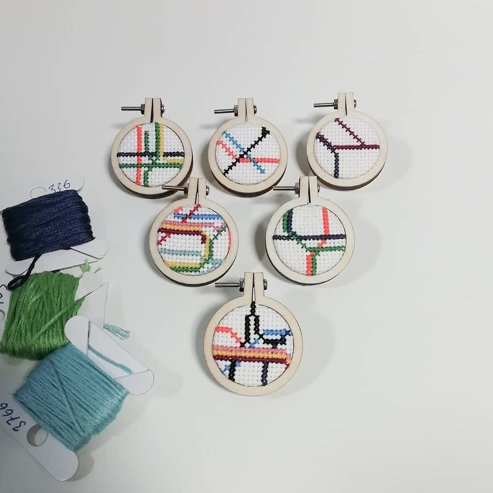 A collection of tiny cross-stitches depicting small sections of the London tube map.