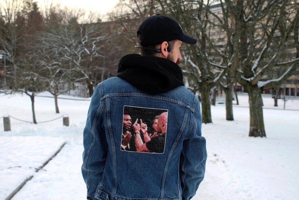 A cross-stitch of Stone Cold Steve Austin, flipping off Mike Tyson, attached to a denim jacket.